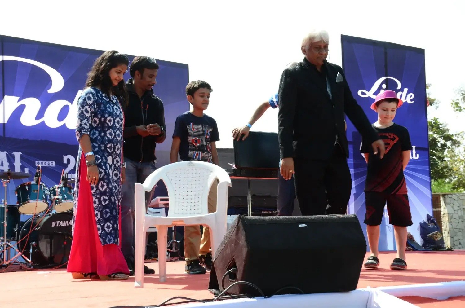 Musical performance on stage with three performers and ITT banner in background